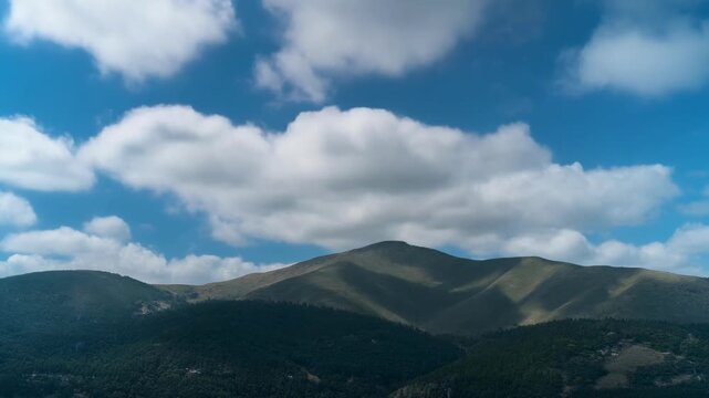 Rolling green hills under a bright blue sky with fluffy clouds