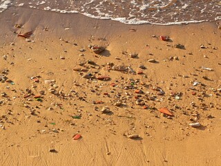 Fototapeta premium Sandy beach with colorful sea glass and pottery shards