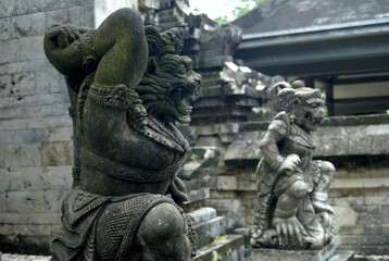 Fototapeta premium Two Weathered Guardian Statues Before Temple