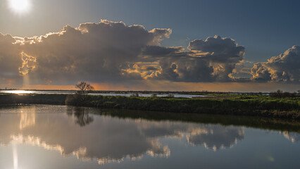 sunset over the lagoon inside the river Po delta with a dramatic sky in the background, Porto Levante, Rovigo, Italy © fruttuoso