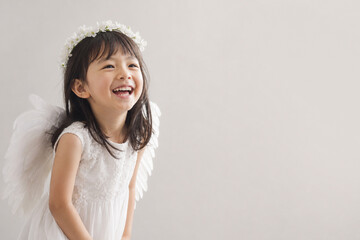 Naklejka premium 天使の仮装をして無邪気に笑う女の子 Generative AI