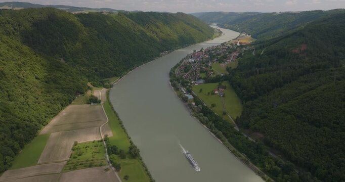 Beeindruckende Luftaufnahme der Donau sanften H&uuml;geln in Bayern. Panorama einer malerischen Flusslandschaft an einem sonnigen Sommertag.