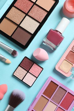 Professional decorative cosmetics, make-up products and accessories on blue background, minimal style. Beauty, fashion, visage and shopping blogger concept. Top vertical view