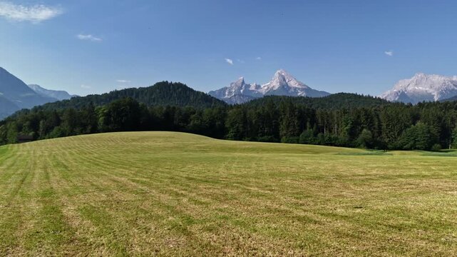 Scenic view of Mount Watzmann in the Bavarian Alps, located in Germany. Green alpine meadows and dense forests. Scenic summer landscape with majestic mountain peaks against the sky