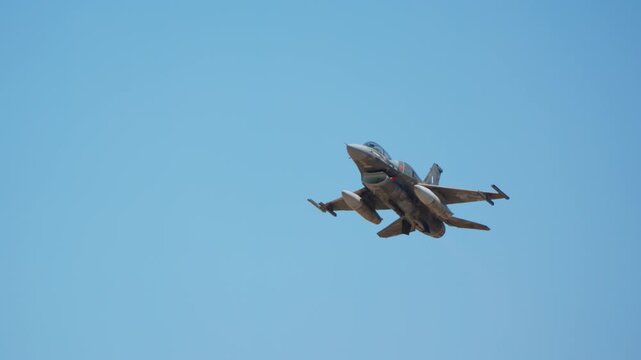 Single-engine fighter jet in slow motion flight against clear blue sky, capturing smooth aerial maneuvers from multiple angles as aircraft banks and changes pitch through sequence