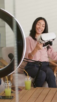 Vertical video: Recording starting, host wearing pink blouse pulling VR headset, showing camera