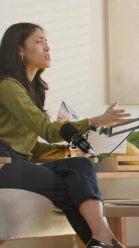 Vertical video: Starting recording, host in olive blouse speaking and touching boom mic in studio