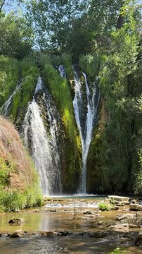Waterfall cascading down a mossy rock cliff