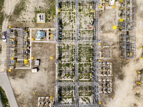 Aerial view of the CFE SE Norte electrical substation featuring complex metal structures, transformers, and electrical equipment on a gravel site in Merida, Yucatan, Mexico.