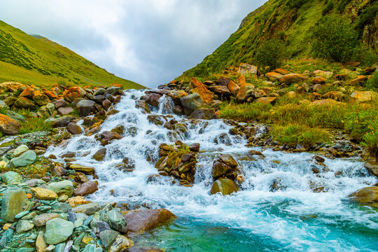 Turquoise Mountain Stream Cascading Over Rocky Terrain