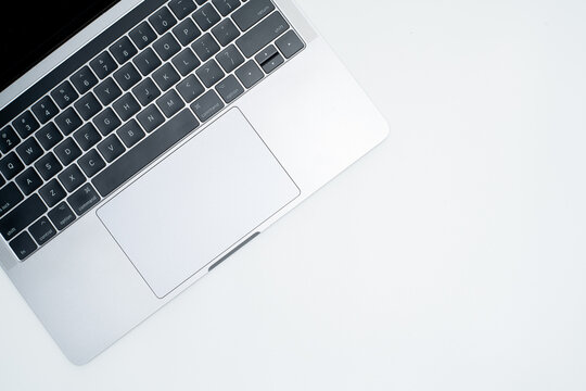 Top View of Modern Laptop Keyboard and Trackpad on White Background with Copy Space