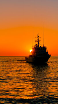 A boat sailing on the ocean at sunset