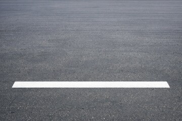 Fototapeta premium An empty parking lot with a white center line, ideal for urban and transportation-related concepts