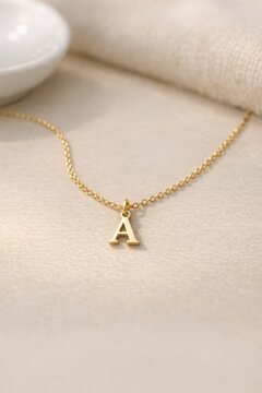 A close-up shot of a golden necklace with the letter A as its centerpiece, perfect for jewelry or luxury brand advertising