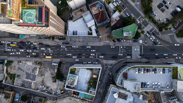 Aerial view of a busy urban intersection with multi-story buildings, parking lots, and heavy traffic flow in the Haeundae district of Busan, Busan, South Korea.