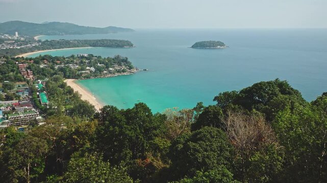 Drone flight over long sandy beach of Phuket, Thailand, clear turquoise ocean water, lush green rainforest coastline, distant tropical islands, serene vacation travel destination. Aerial view panorama