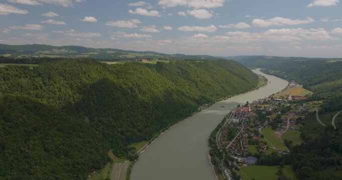 Beeindruckende Luftaufnahme der Donau sanften H&uuml;geln in Bayern. Panorama einer malerischen Flusslandschaft an einem sonnigen Sommertag.