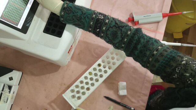 Laboratory technician preparing clinical samples with a micropipette, reagents, and test tubes beside an automated clinical chemistry analyzer. Ideal footage for healthcare, biotechnology, diagnostics