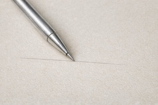 A pen sits atop a blank sheet of paper, ready to create something new