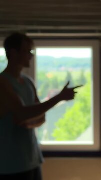 Depressed teenager in a dark room trying to discuss with his own reflection. Trying to give himself a pep talk then despairing
