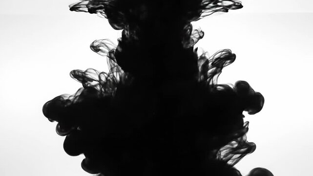 Black ink swirling and dissolving in water creating abstract smoke patterns on white background