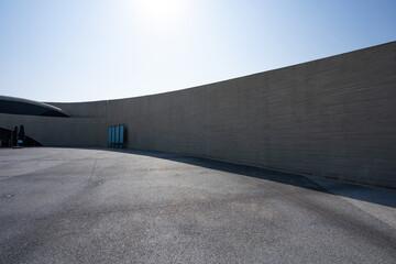 Concrete curved wall and empty plaza under bright sunlight © zhu difeng