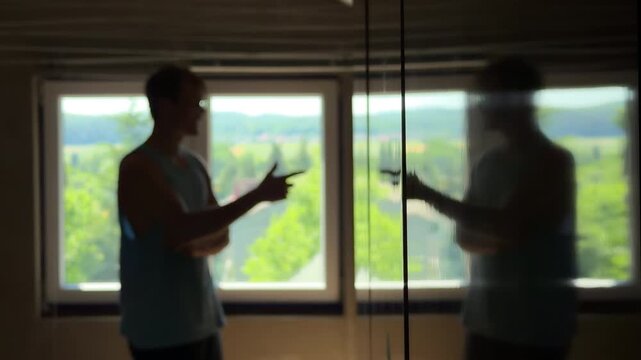 Depressed teenager in a dark room trying to discuss with his own reflection. Trying to give himself a pep talk then despairing