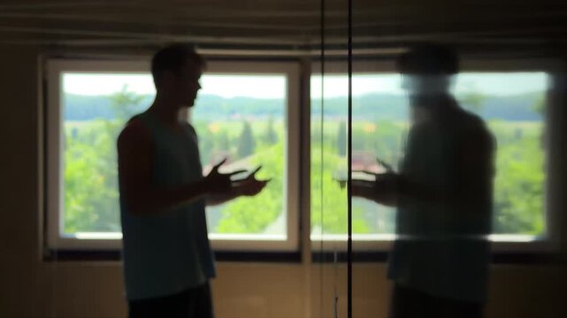 Depressed teenager in a dark bedroom trying to argue with his reflection. Dissociative identity disorder