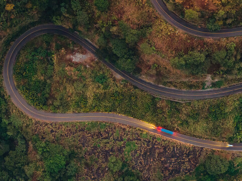 Aerial view of the winding Puente Beltran road bridge surrounded by dense forest and lush vegetation in Tonila, Jalisco, Mexico.