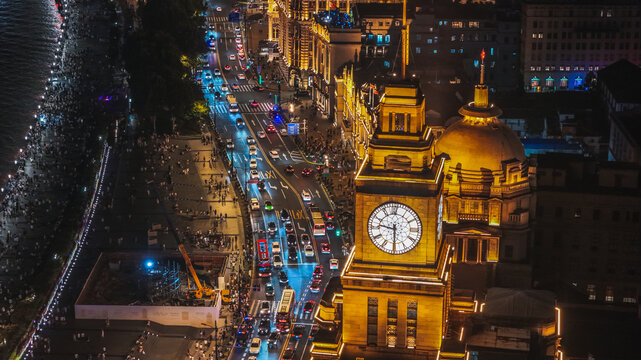 Aerial view of the illuminated Custom House clock tower at night, overlooking the bustling traffic on the Bund in Shanghai, Shanghai, China.
