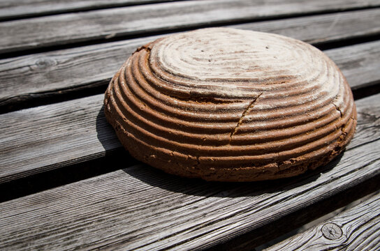 Fresh handmade bread on an old rugged wooden table, diagonal planks, bread on the right of image