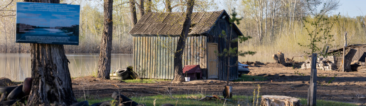 an old building by the river in the forest, a wooden garage in the forest
