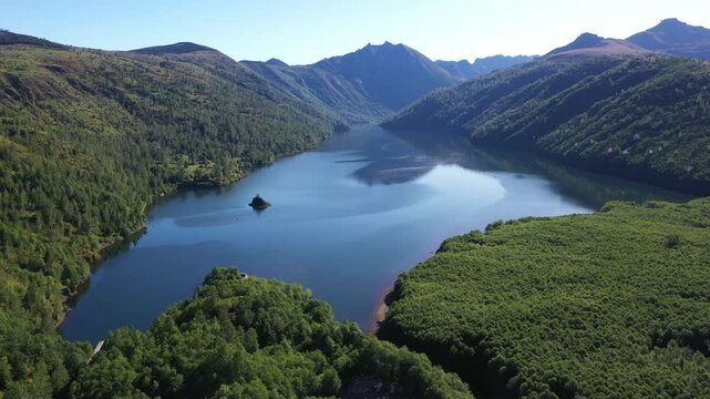 4K aerial drone footage of Coldwater Lake near Mount Saint Helens in Washington, USA. Scenic Pacific Northwest summer landscape with volcanic mountains, evergreen forest and pristine freshwater