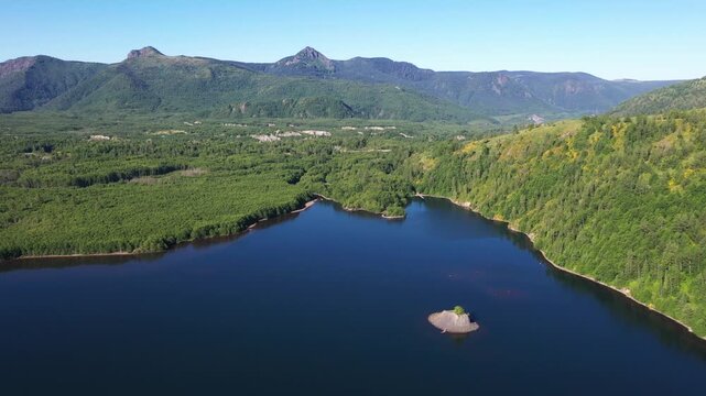 4K aerial drone footage of Coldwater Lake near Mount Saint Helens in Washington, USA. Scenic Pacific Northwest summer landscape with volcanic mountains, evergreen forest and pristine freshwater
