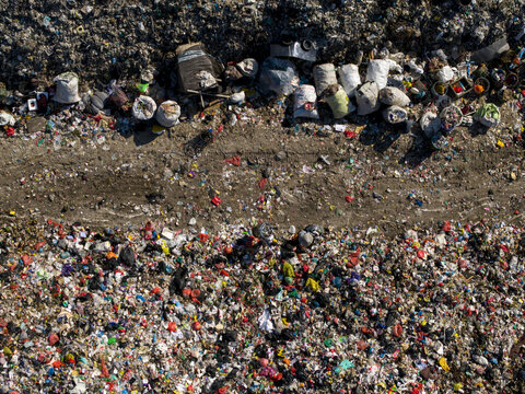 Aerial view of TPA Suwung landfill showing piles of plastic waste and sorted bags in Kecamatan Denpasar Selatan, Bali, Indonesia.