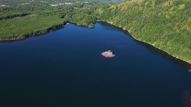 4K aerial drone footage of Coldwater Lake near Mount Saint Helens in Washington, USA. Scenic Pacific Northwest summer landscape with volcanic mountains, evergreen forest and pristine freshwater