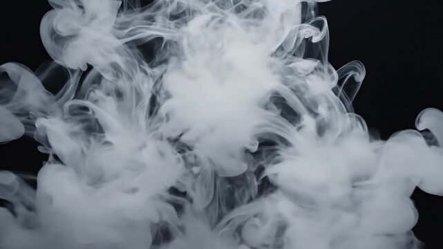 White smoke ring expanding and dissipating against a dark background in slow motion