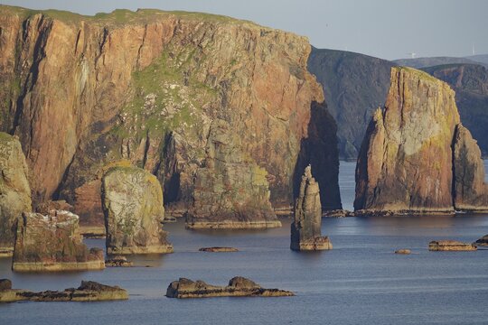 Towering cliffs and rocks in the sea under a clear sky, Eshanness, Shetland Islands, Scotland, United Kingdom