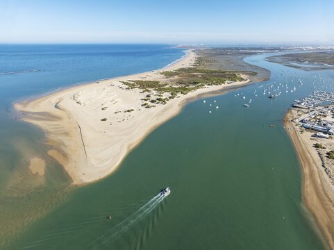 The large sandbar of Punta del Boquer&oacute;n and partial view of the fishing village of Sancti Petri. In the distance top right the town of San Fernando. Aerial view. Drone shot. Bah&iacute;a de C&aacute;diz Nature Reserve. C&aacute;diz province, Andalusia, Spain