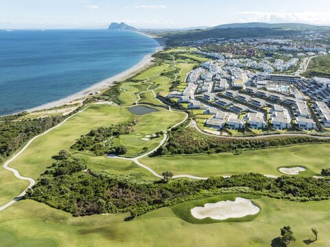 The La Hacienda Links Golf Resort at the Mediterranean Sea with the Rock of Gibraltar (British) in the distance. Prominent the Fairmont La Hacienda hotel. Aerial view. Drone shot. C&aacute;diz province, Andalusia, Spain