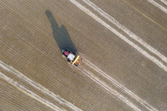 Tractor sowing rice seeds in a flooded rice field in May, aerial view, drone shot, Ebro Delta Nature Reserve, Tarragona province, Catalonia, Spain