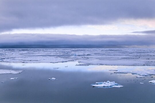 View at the Arctic Ocean with drift ice and clouds in the horizon, Svalbard, Norway