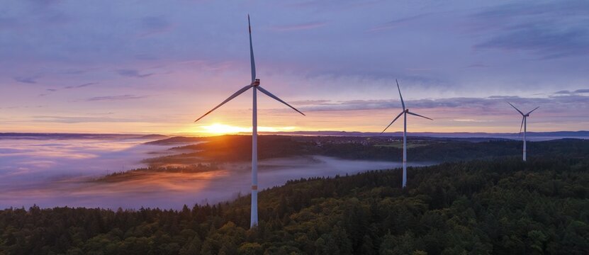 Powerful wind turbines over a misty forest and a wide horizon at sunrise, near Schorndorf, Rems-Murr-Kreis, Rems-Murr-Kreis, Baden-W&uuml;rttemberg, Germany