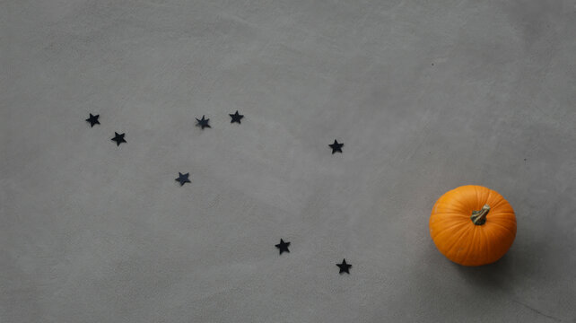 Minimalist flat lay with orange pumpkin and black star sequins on concrete