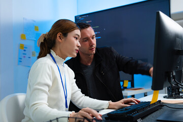 Fototapeta premium Two software Engineer Collaboration on Software Development Project, working together on Computer, Programmer Discussion, Reviewing Code on Screen Analyzing, Developing Idea at Desk in tech Office.