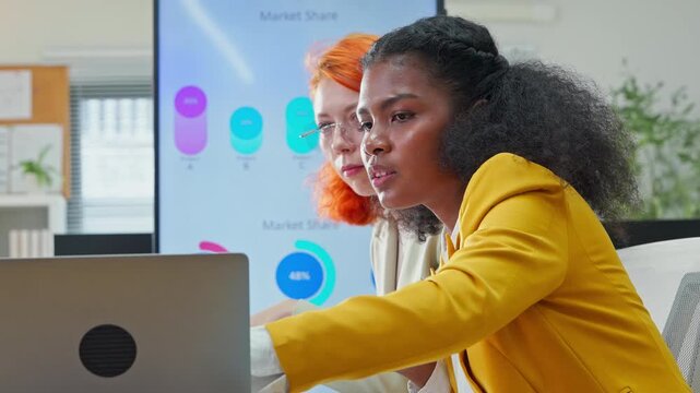 Diverse multiracial team presenting AI-powered marketing restructuring strategy on screen in modern open office, analysts reviewing business documents and data for corporate transformation concept