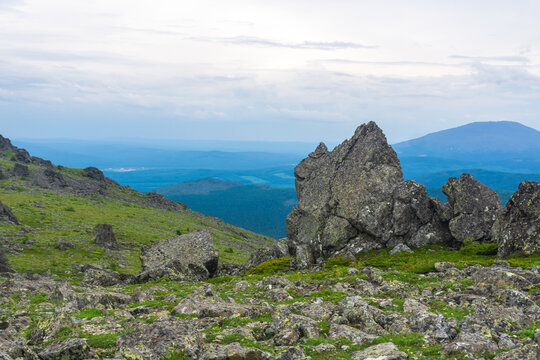 Mountain landscape with green grass and rocks. North Urals.
