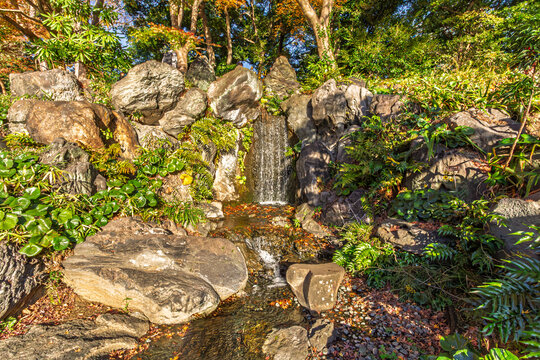 Picturesque waterfall and lush green rocks at Ninomaru Garden in the Imperial Palace East Gardens December 2023