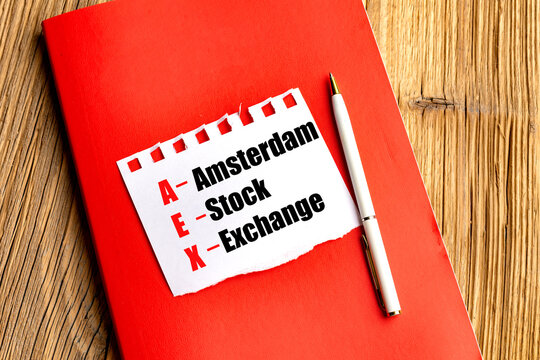Aex stock exchange acronym on torn paper with notebook and pen on wooden desk representing dutch financial market investment