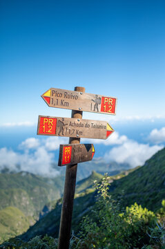 Wooden trail signpost pointing to Pico Ruivo and Achada do Teixeira in the mountains of Madeira island